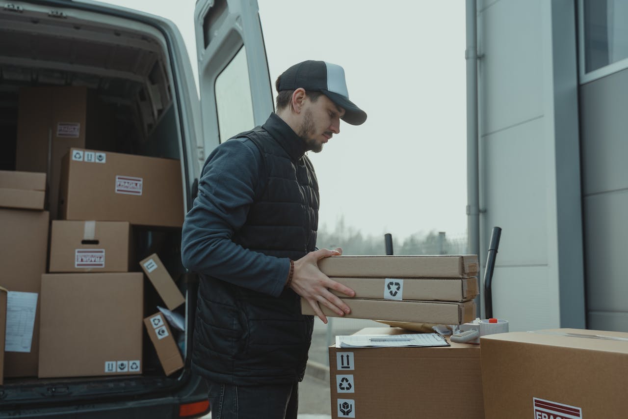 services-03 Delivery driver handling cardboard boxes during shipping at a commercial building.